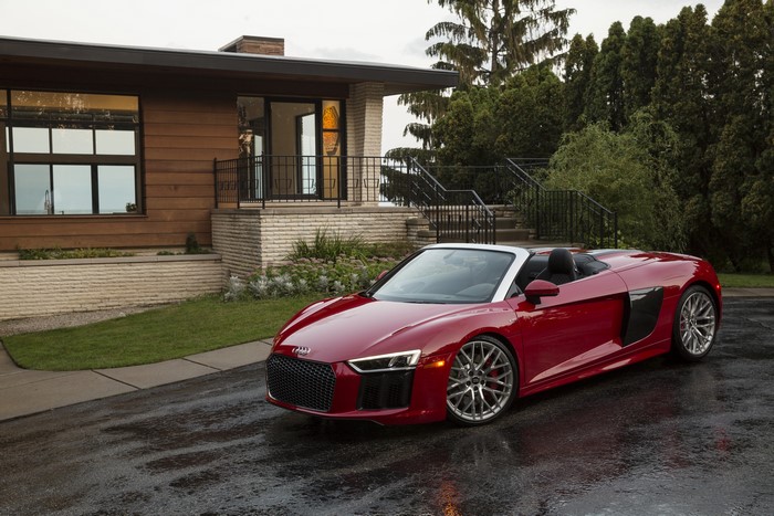 Red Audi R8 Spyder V10 Cabriolet parked in front of a modern house