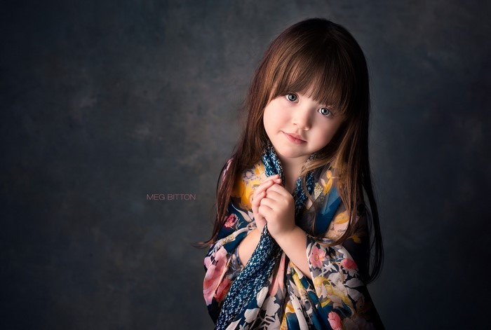 Little girl with brown hair wearing a floral scarf
