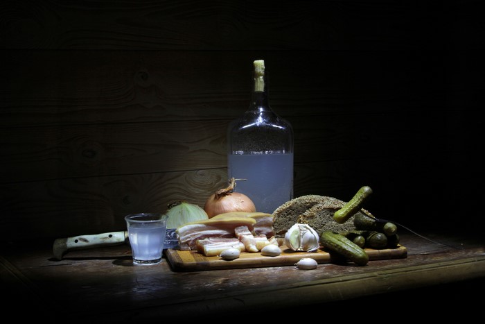Still life with vodka, bread, salo, and pickles