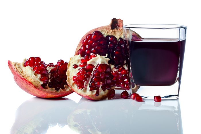 Pomegranate juice and fruit on white background