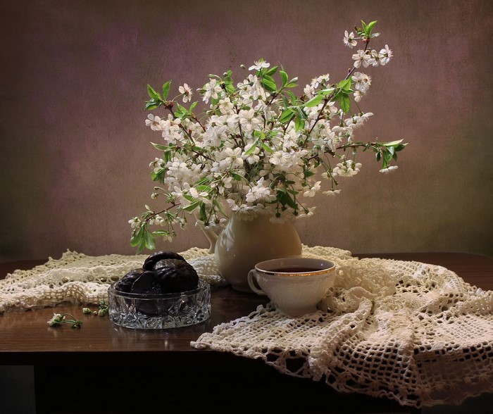 Still life with flowering branches, tea, and chocolates