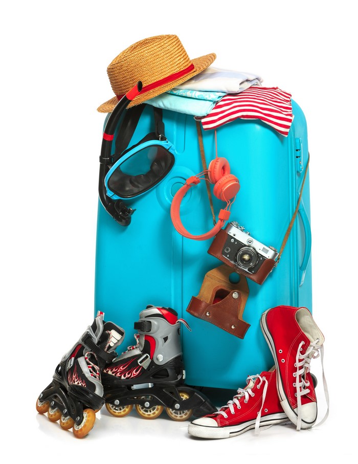 Suitcase with travel items: hat, snorkel, headphones, camera, roller skates, shoes