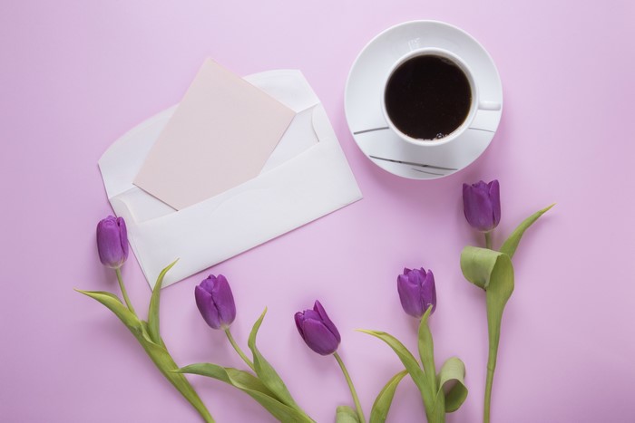 Tulips, Coffee, and Envelope on Pink Background