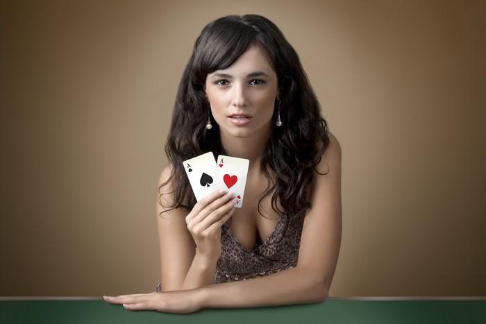 Brunette woman holding two Aces