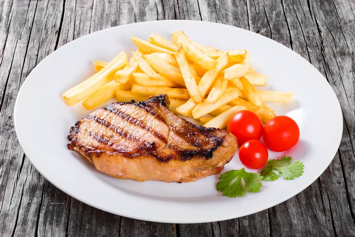 Grilled Pork Chop with French Fries and Tomatoes
