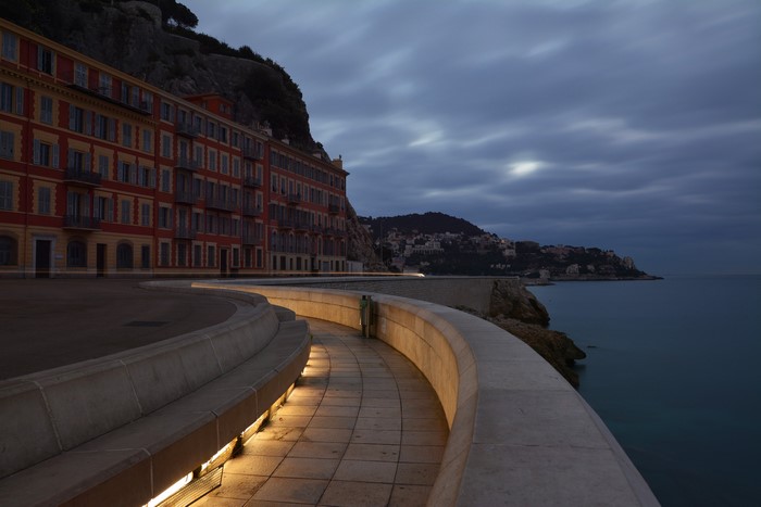 Buildings on a cliff overlooking the sea at dusk in Nice, France