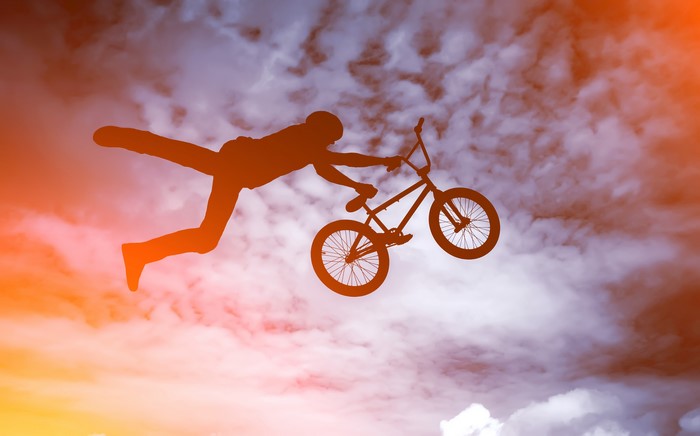 Silhouette of a man performing a BMX bike jump