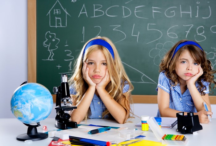 Young Girls in Classroom with Globe and Microscope