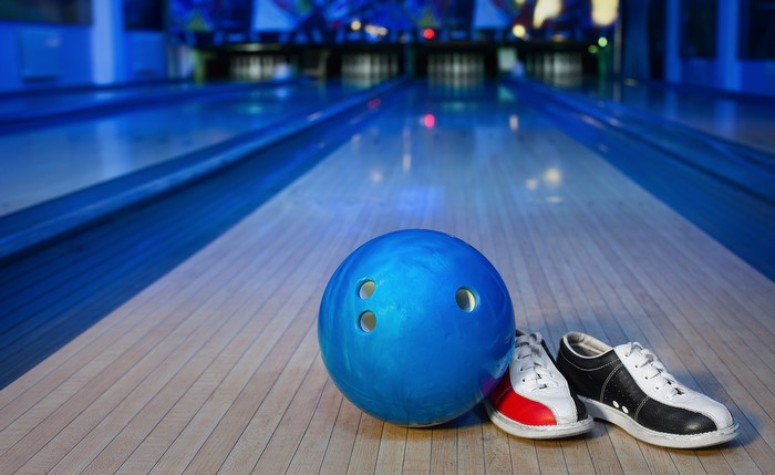 Blue bowling ball and shoes on lane