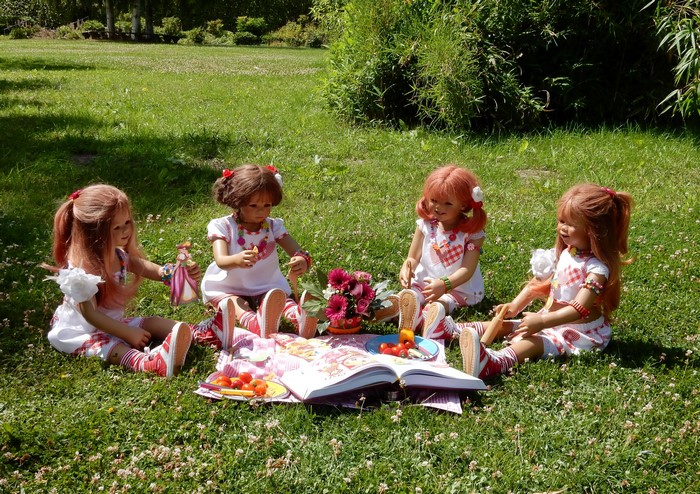 Four dolls having a picnic in a park