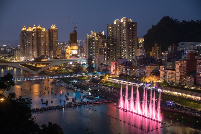 Cityscape with River, Bridge, and Fountain Show at Night