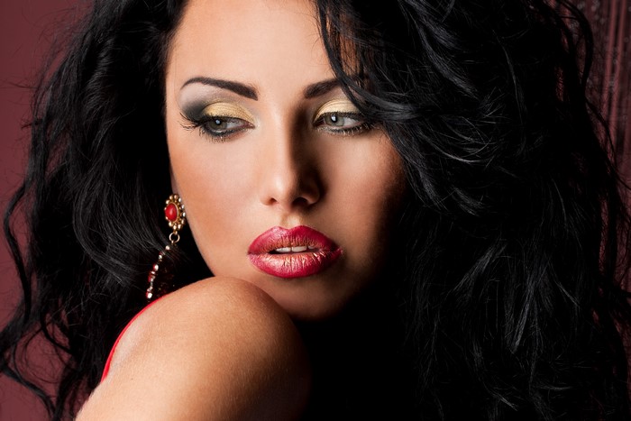 Brunette woman with red lips and gold eyeshadow