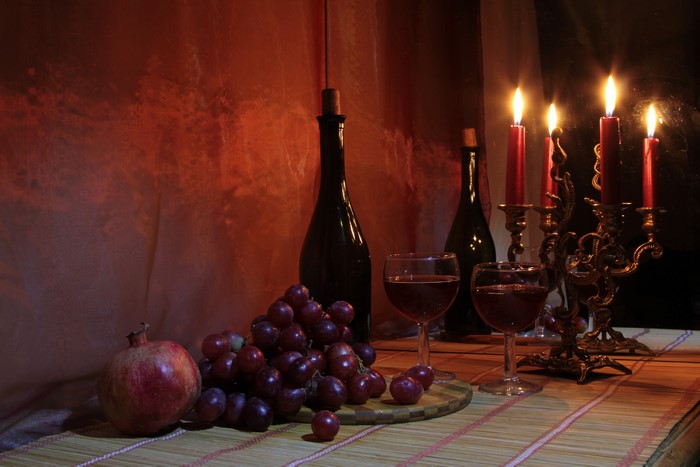 Still-life with wine, grapes, pomegranate, and candles