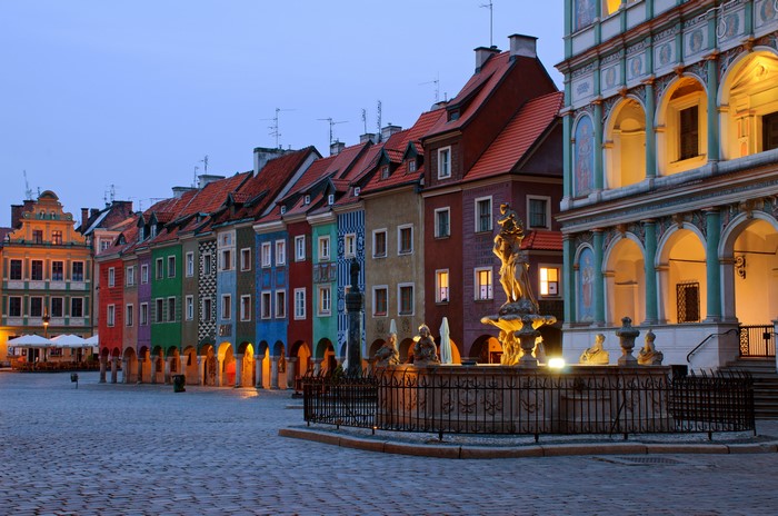 Poznan Town Square with colorful houses and fountain at dusk
