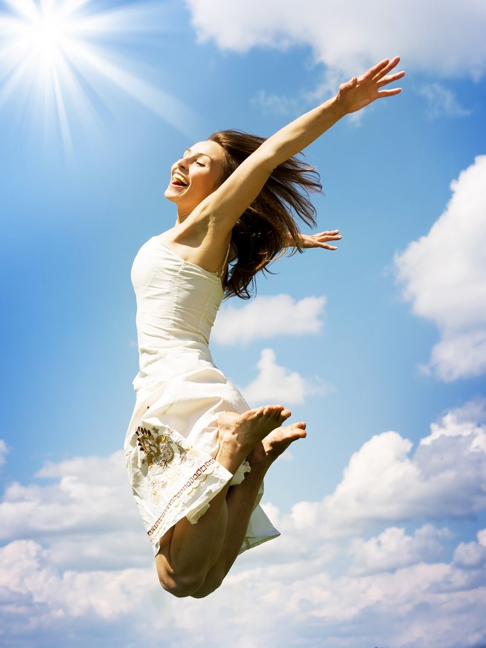 Woman in white dress jumping in the sky
