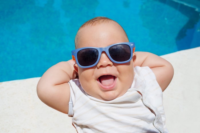Baby wearing sunglasses by the pool
