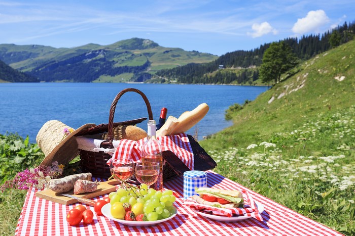 Picnic with Wine, Grapes, and Sandwiches by a Lake
