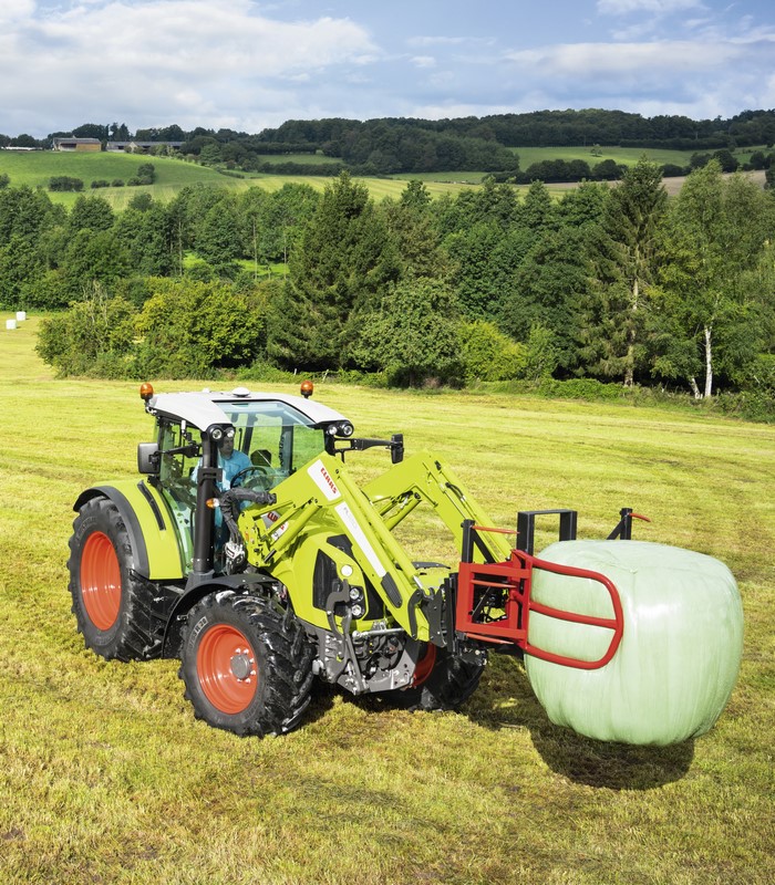 Claas Arion 460 tractor with bale grabber in field
