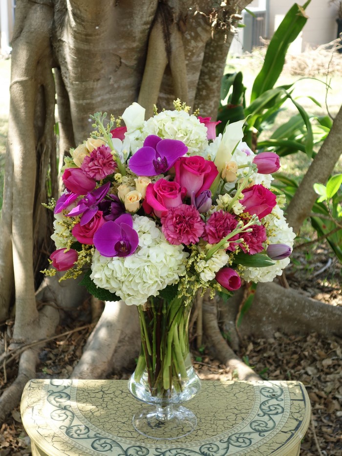 Vibrant floral arrangement with roses, orchids, and hydrangeas