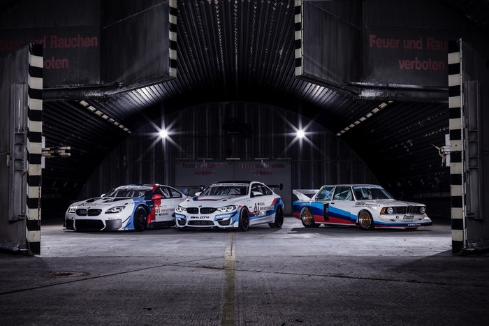 Three BMW M Motorsport race cars in a hangar