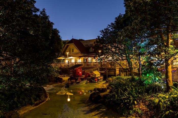 Wooden building by a pond at night