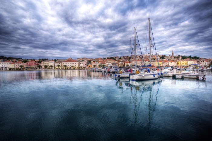 Sailboats docked in Mali Losinj, Croatia harbor with colorful buildings