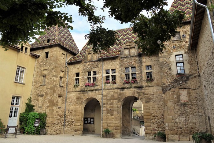 Stone buildings with tiled roofs and arched passageways in Saint Antoine l'Abbaye