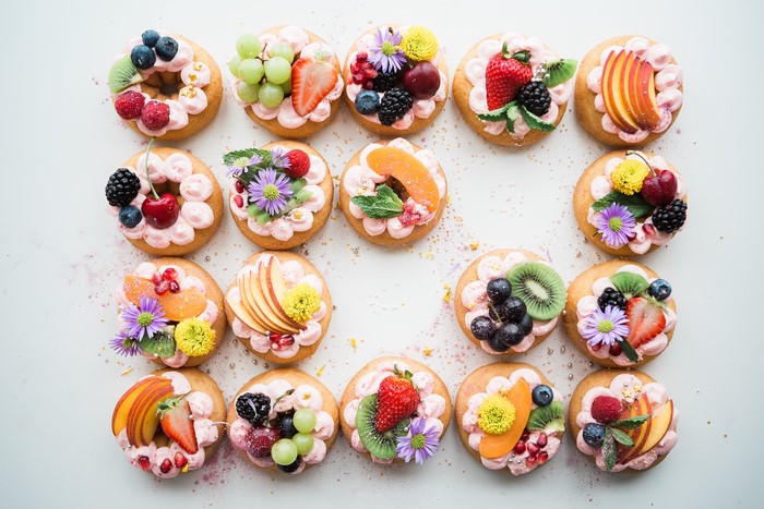 Assortment of decorated donuts with fresh fruit