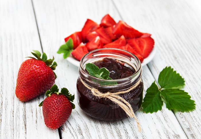 Strawberry jam in a jar with fresh strawberries