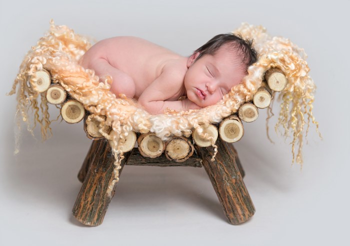 Newborn baby sleeping in a wooden cradle