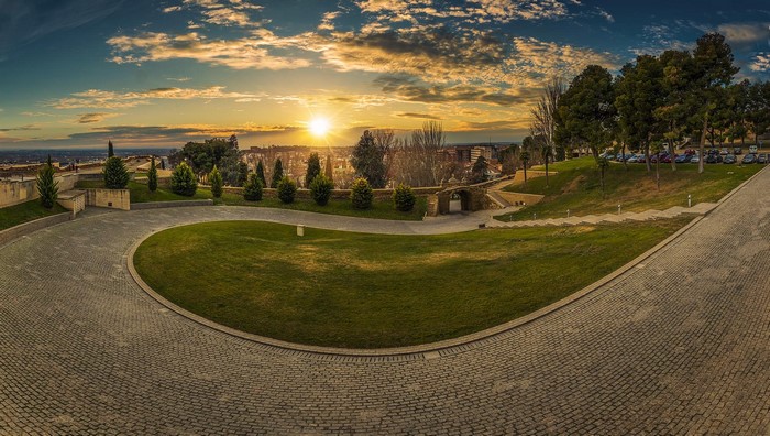 Sunset over Lleida, Spain with paved road and park