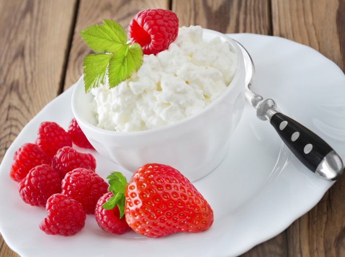 Cottage cheese with raspberries and strawberry on a plate
