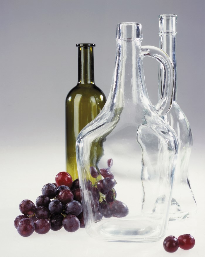Grapes and bottles on a plain background
