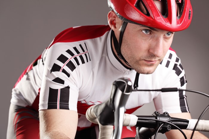 Man in red helmet and cycling jersey on bicycle