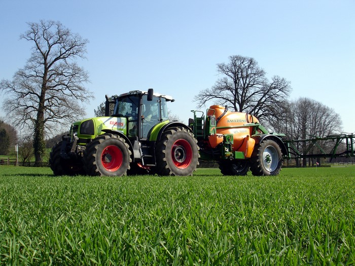 Claas Ares 836 RZ tractor with Amazone sprayer in a field