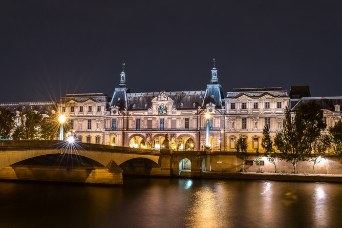 Louvre Palace and Bridge over River Seine at Night in Paris