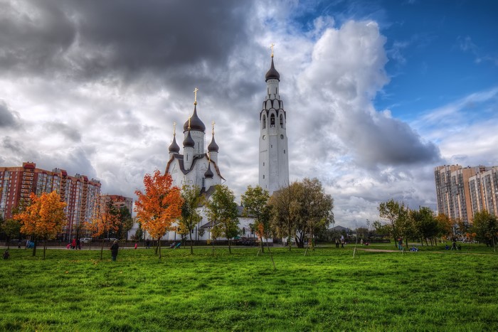 Church and apartment buildings in a park in St. Petersburg