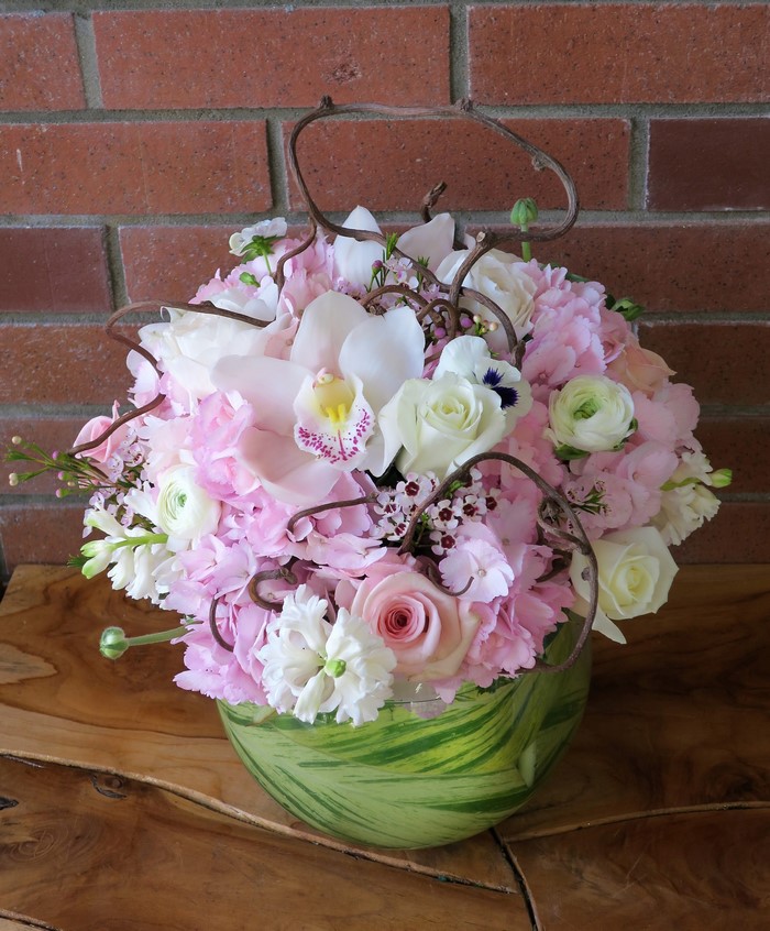 Pink and white floral arrangement with orchid and roses