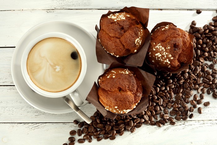 Coffee cup and muffins with coffee beans