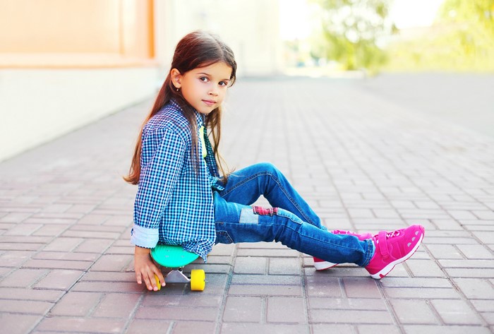 Girl sitting on a skateboard