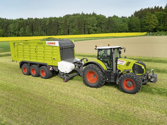 Claas Axion 830 tractor with trailer in a field