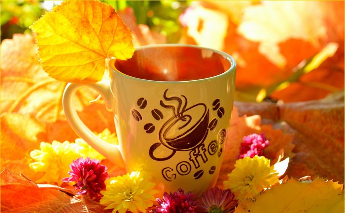 Coffee cup with autumn leaves and flowers