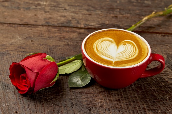 Red rose and cappuccino with heart art