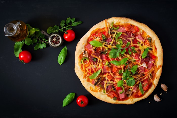 Pizza with tomatoes, basil, and salami