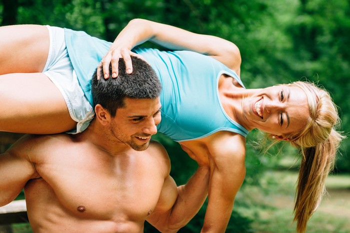 Man carrying a woman during a fitness activity
