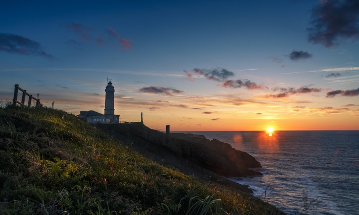 Lighthouse on a cliff at sunset in Santander, Spain