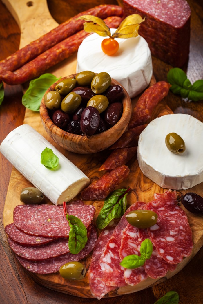 Charcuterie board with salami, cheese, and olives
