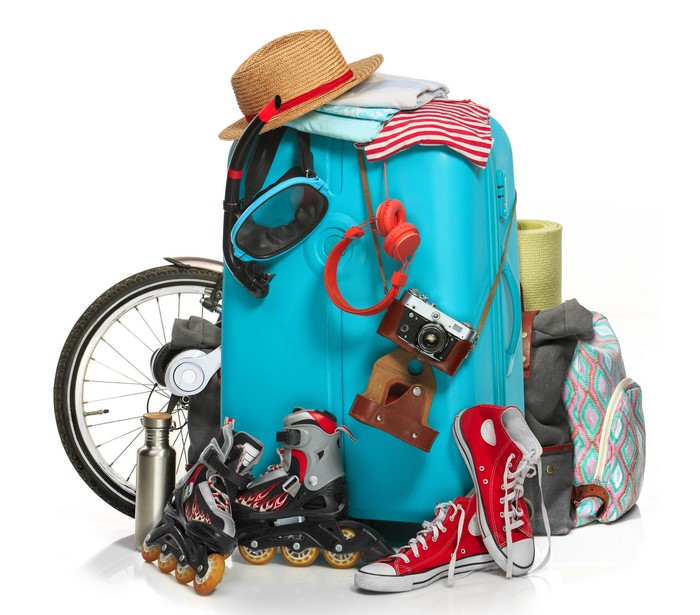 Suitcase packed with travel items and bicycle wheel