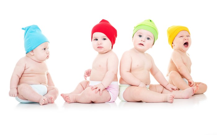 Four babies in winter hats on white background