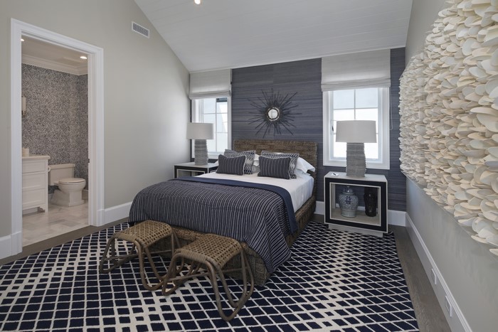 Bedroom with blue and white striped bedding and geometric rug